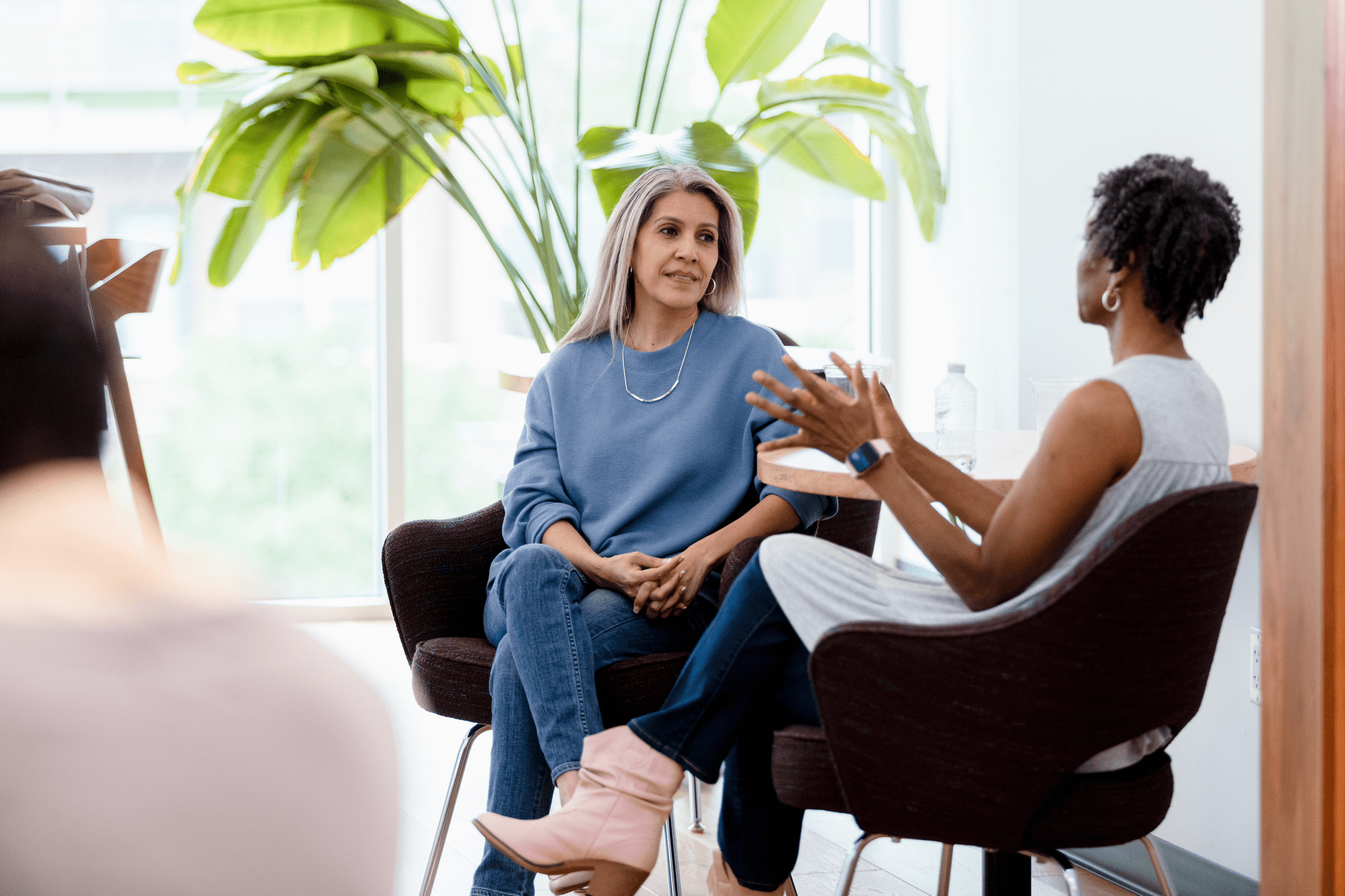 Two women having a thoughtful conversation in a bright room.